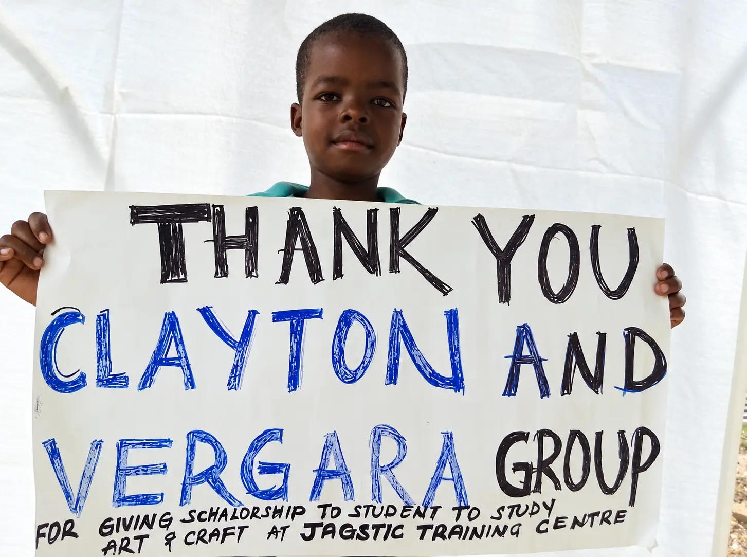 A child holding a thank-you sign for Clayton and Vergara Group