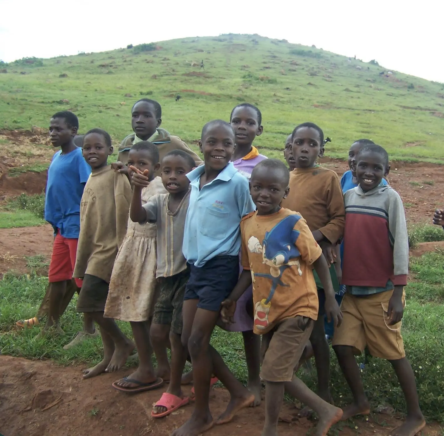 Children standing together on a green hillside