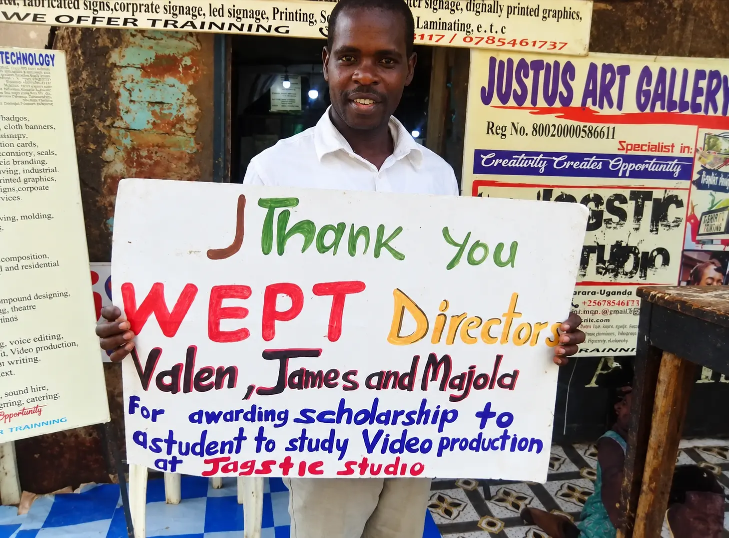 A man holding a thank-you sign recognizing scholarship support